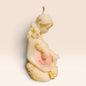 Enchanted Wicks creamy sculptural pillar candle depicting a mother and child with delicate floral accents