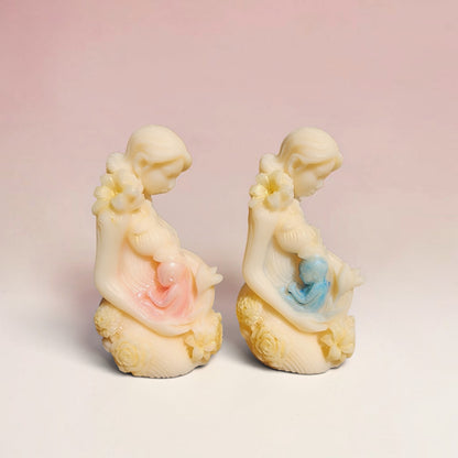 Enchanted Wicks Motherhood sculpted pillar candles featuring cream wax figures with delicate pink and blue accents.